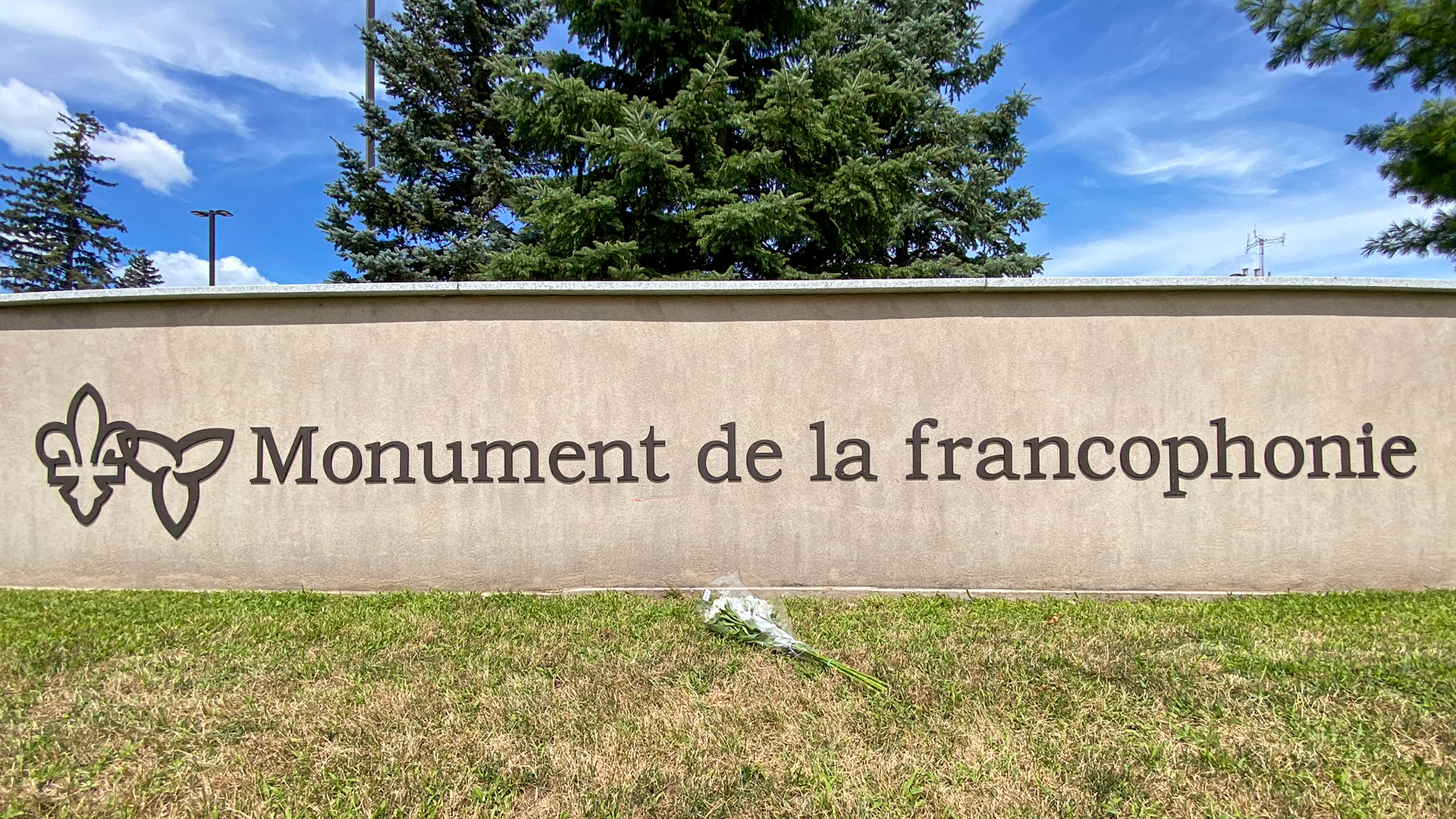 Une gerbe de fleur est déposée devant le monument de la francophonie