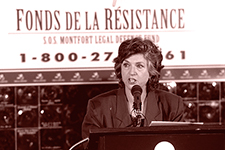 Mrs. Michelle de Courville Nicol at the microphone in front of the poster of the Fonds de la Résistance